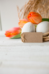 Ostern - Orangefarbene Tulpen im Nest auf hellem Grund und Anhänger 