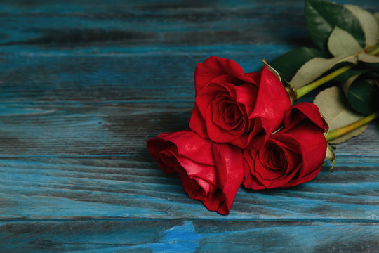 bouquet of red roses on a blue wooden background