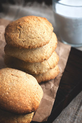 Daily healthy breakfast. Homemade oatmeal cookies, milk, fruit on dark wooden background.