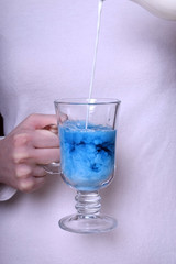 Blue tea Anchan with milk in an Irish glass in female hand