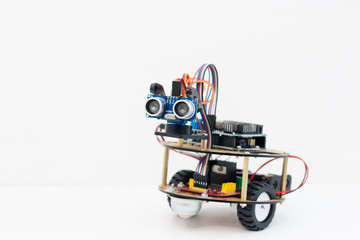 Hand made robot working on the arduino platform. White background. Free space for text. STEM education for children and teenagers, robotics and electronics. DIY. AI. STEAM.