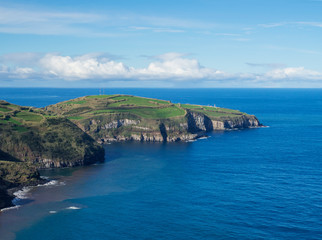 Fototapeta na wymiar green fields pasture and coastal cliffs and blue ocean and sky horizon at north coast of sao miguel island, Azores, Portugal