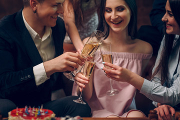 Merry frinds celebrate birthday and cheers with a glasses of champagne
