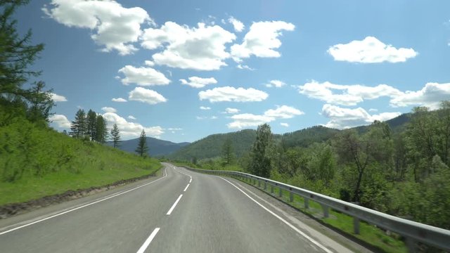 The highway in the mountain area. Movement of the camera. 4K. Sky and clouds.