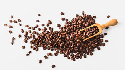 Coffee beans on a wooden scoop, white background