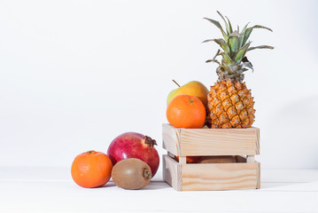 Group of fresh tropical fruits in small wooden box.
