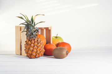 Group of fresh tropical fruits near small wooden box.