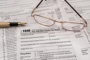 Individual tax form 1040 with pen and glasses