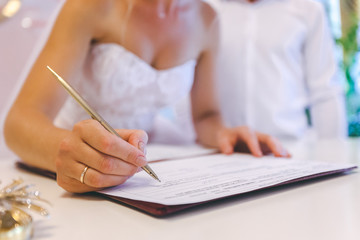 Groom and bride register marriage close up, signature of the newlyweds of the general marriage certificate