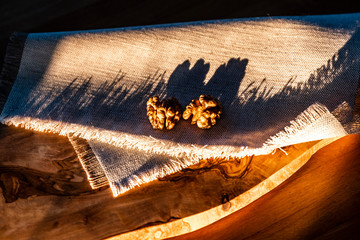 Two halves of the walnuts on the sackcloth serviette with natural shadows from the sunset's rays