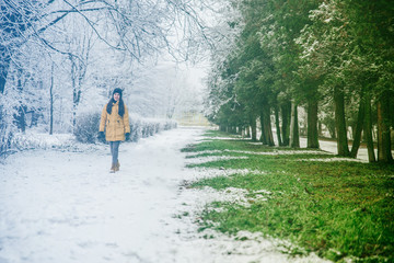 woman walk by park where winter meet spring
