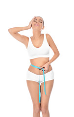 Slim woman measuring her waist on white background. Weight loss