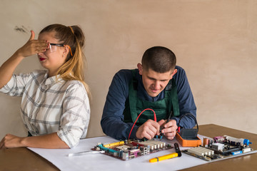 Man testing motherboard of personal computer by multimeter