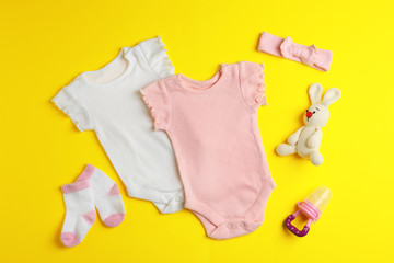 Flat lay composition with cute clothes on color background. Baby accessories