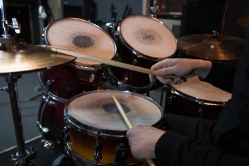 Professional drum set closeup. Drummer with drumsticks playing drums and cymbals, on the live music rock concert or in recording studio   