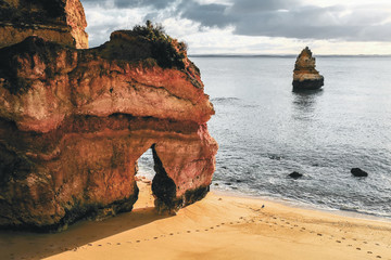 beautiful Atlantic ocean view horizon with sandy beach,  rocks and waves at sunrise. Algarve, ...