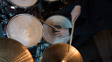 Professional drum set closeup. Drummer with drumsticks playing drums and cymbals, on the live music rock concert or in recording studio   