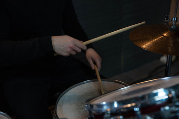 Professional drum set closeup. Drummer with drumsticks playing drums and cymbals, on the live music...