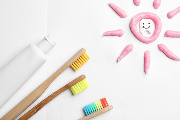 Composition small plastic tooth and oral care products on white background