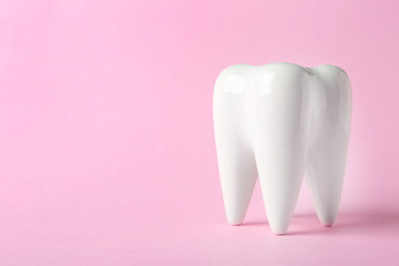 Ceramic model of tooth on color background. Space for text