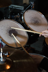 Professional drum set closeup. Drummer with drumsticks playing drums and cymbals, on the live music rock concert or in recording studio   