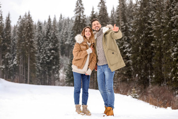 Obraz premium Couple spending time outdoors on snowy day. Winter vacation