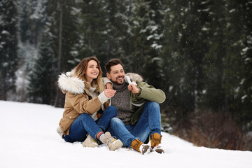 Fototapeta premium Couple spending time outdoors on snowy day. Winter vacation