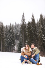 Fototapeta na wymiar Couple spending time outdoors on snowy day, space for text. Winter vacation