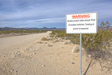 Road of Sinking Sands. A warning sign on a road that leads to Alamo Lake Arizona cautioning that your vehicle could sink due to the water table being near the surface.