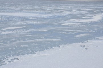 Eisdecke auf dem winterlichen See schneebedeckt