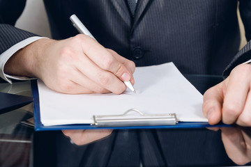 A businessman signing documents in the office.