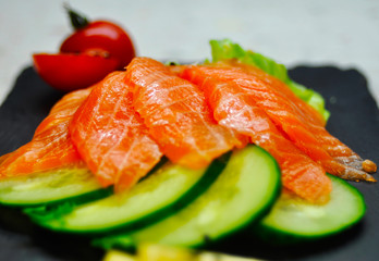 Eating Sushi with chopsticks. Sushi roll japanese food in restaurant. California Sushi roll set with salmon, vegetables, flying fish roe and caviar closeup. Japan restaurant menu