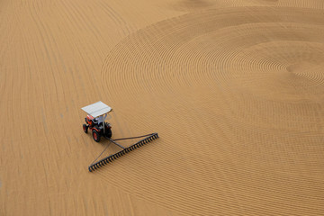 tractor flattening cracked wheat for drying