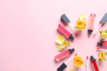 Composition of lipsticks with flowers on color background, flat lay. Space for text.