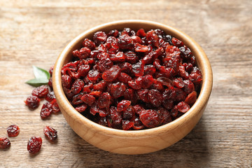 Bowl with cranberries on wooden table. Dried fruit as healthy snack