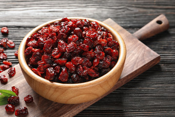 Bowl with cranberries on wooden table. Dried fruit as healthy snack