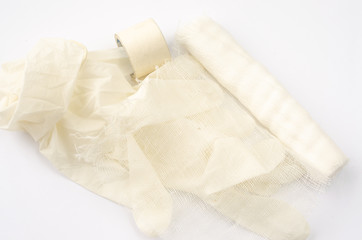 Medical glove and bandage on a white background.