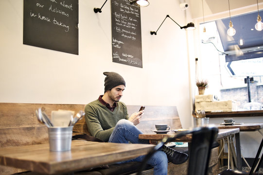 Caucasian man using a mobile device in a cafe