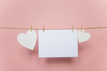 Blank love letter pegged to a line with white hearts. Valentine's day, mother's day.