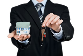Businessman Holding a Model House and Keys