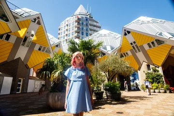 Foto op Aluminium the girl on the background of the cube house or Kubuswoningen in Dutch are a set of innovative houses designed by architect Pete Blom and built in Rotterdam © Aleksei Zakharov