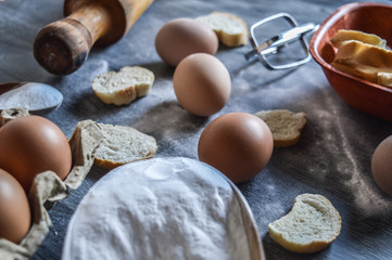 eggs flour and bread on mader background...