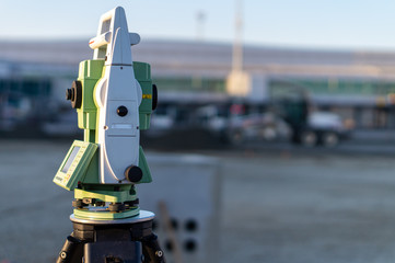 Surveyor equipment (theodolite) on construction site of the airport, building or road with...