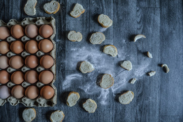 Fototapeta na wymiar egg carton and bread on wooden background