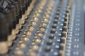 Fototapeta premium DJ mixer console - close up blur graphic equaliser keyboard in perspective. Club electronic music, entertainment.