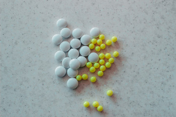 Yellow and white tablets on white surface