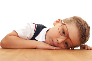 Obraz premium Little cute tired boy first grader in school