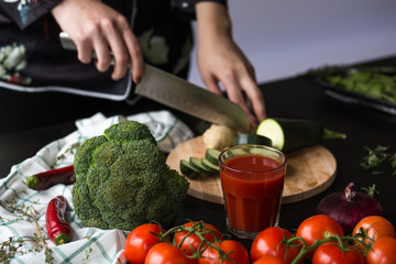 girl cuts vegetables with a knife in the kitchen