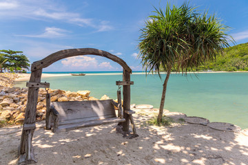 Wooden swinging bench on a beach
