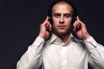 Young DJ guy listening to music in headphones
